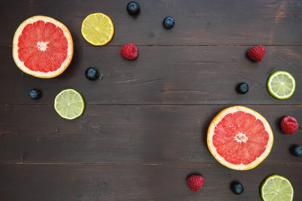 Fruit en bessen op donkere houten achtergrond — Stockfoto