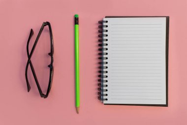 Eğitim defter kalem ve parlak pembe bir arka plan üzerinde gözlük