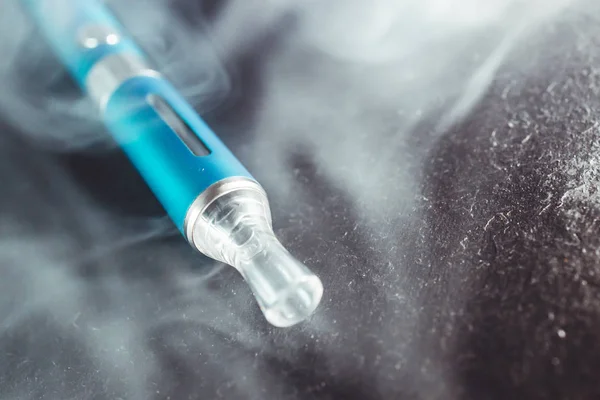 Паровое перо металлическая электронная сигарета с пылающим облаком дыма темно — стоковое фото