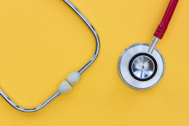 Mavi arkaplanda kırmızı steteskop. Üst görünümde en az doktor iyileşmesi.