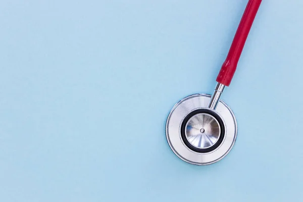 Rött stetoskop på blå bakgrund ovanifrån minimal läkare healt — Stockfoto