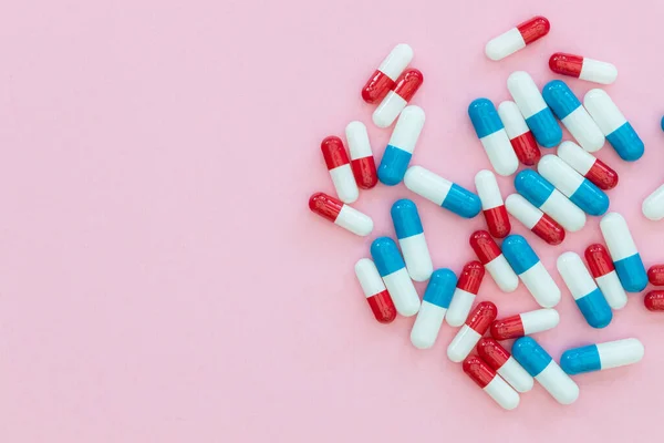 Наркотики таблетки капсулы на розовом фоне абстрактный вид лекарства — стоковое фото
