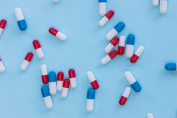 Наркотики таблетки капсулы на синем фоне абстрактный вид лекарства — стоковое фото