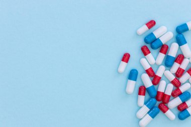 Mavi arka planda ilaç hapları kapsülleri soyut üst görünüm medii