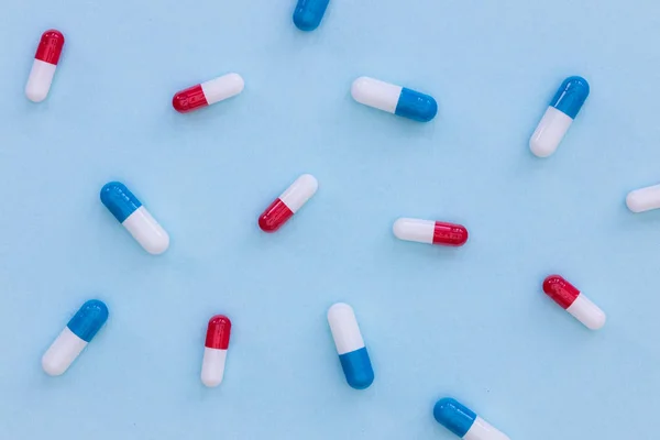 Наркотики таблетки капсулы на синем фоне абстрактный вид лекарства — стоковое фото