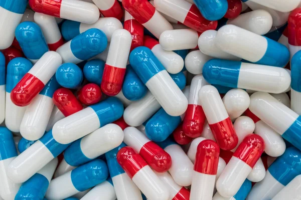 Drugs pills capsules on red blue abstract top view medicine heal Royalty Free Stock Photos