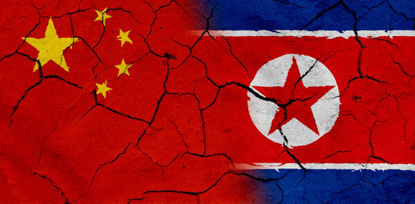 China and North Korea flag with dried soil texture