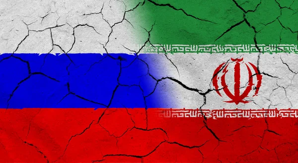 Russia e Iran bandiera con tessitura del suolo essiccato — Foto Stock