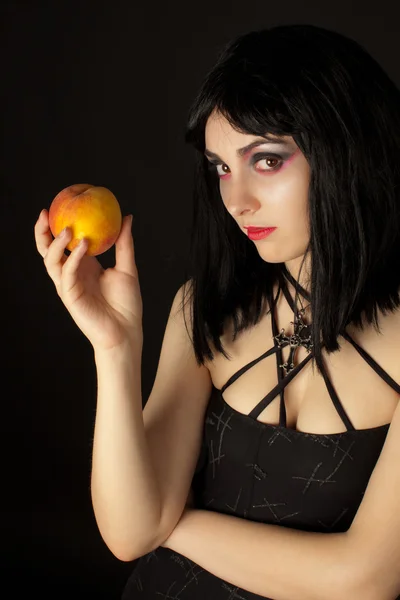 Vrouw met halloweeen make-up holding perzik — Stockfoto