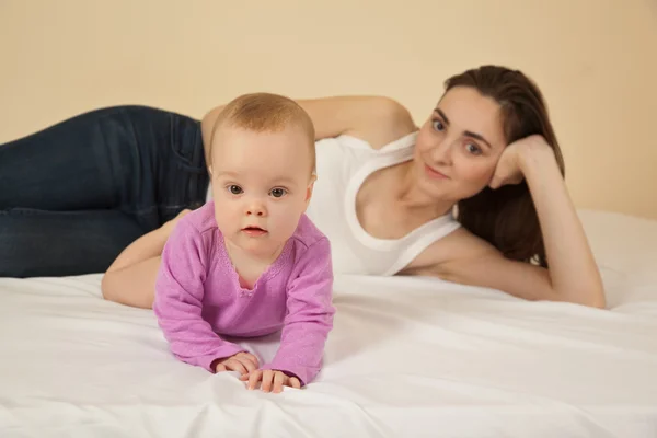 Mère avec bébé couché sur le lit — Photo