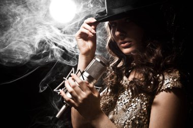 Stüdyo mikrofon ile elbiseli güzel şarkıcı