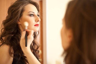 Kadın sanatçının yüz üzerine makyaj uygulamak