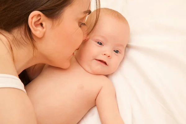 Image de mère heureuse avec bébé adorable couché sur le lit — Photo