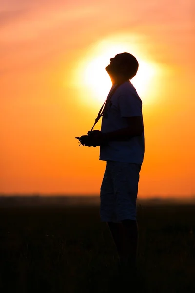 Hombre sosteniendo control remoto y mirando hacia el cielo al aire libre — Foto de Stock