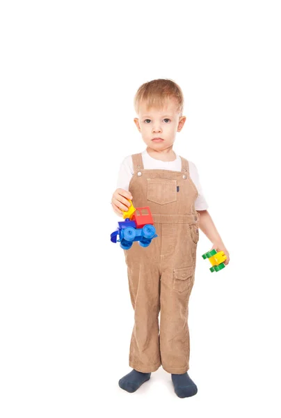 Задумчивый ребенок, играющий с изолированными игрушками — стоковое фото