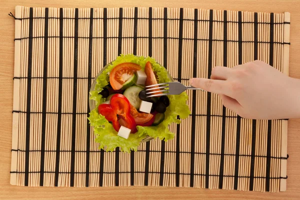 Gambar tangan dengan garpu dengan salad Yunani — Stok Foto