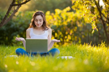 Kadın laptop lotus poz park adlı çalışma ile