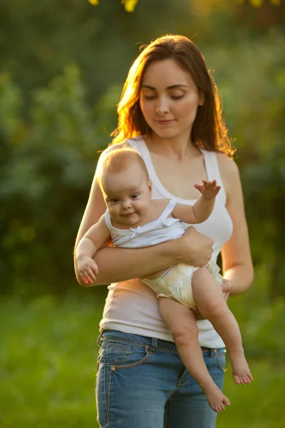 Mother and baby outdoors. Mother holding baby on her arms — Stock Photo, Image