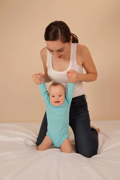 Mère avec bébé jouant au lit — Photo