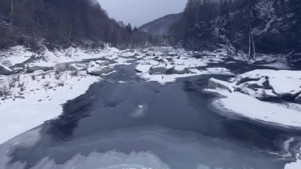 Vliegen over een rivier van de winter in de bergen. — Stockvideo
