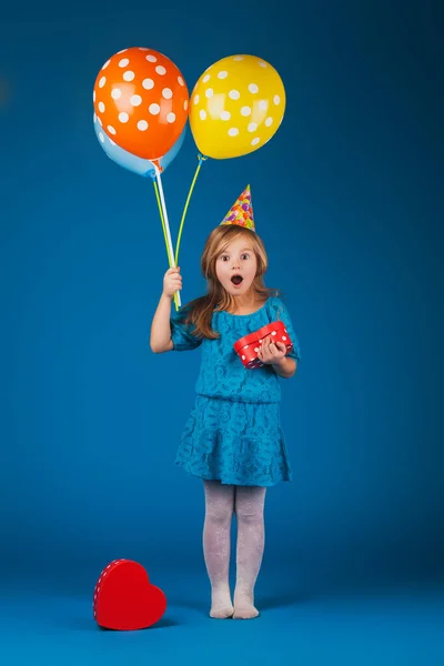 Chica con regalos y globos en el fondo azul . — Foto de Stock