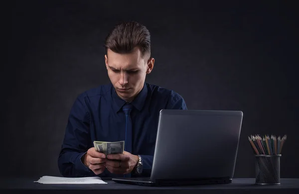 Successful business man on a dark background with a money — Stock Photo, Image