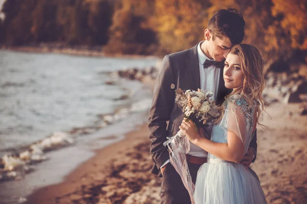 Recém-casados estão andando na praia de outono — Fotografia de Stock