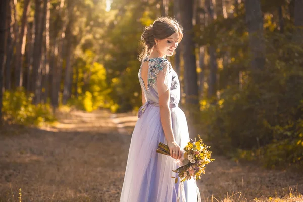 Noiva com um buquê está andando no parque verde — Fotografia de Stock