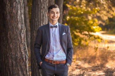 Parkta duran yakışıklı genç bir işadamı.