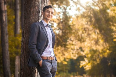 Parkta duran yakışıklı genç bir işadamı.