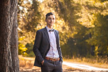 Parkta duran yakışıklı genç bir işadamı.