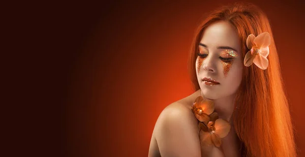 Beauty womans portrait. evening make-up on the orange bokeh background — Stock Photo, Image