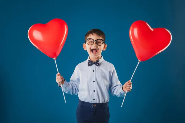 Lindo niño con regalos en el fondo azul — Foto de Stock