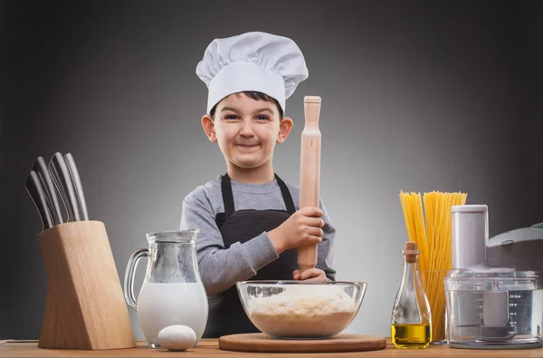 Boy Chef Matlagning på en grå bakgrund. — Stockfoto