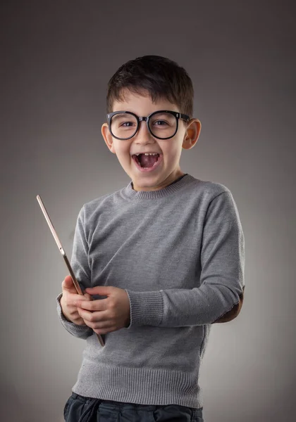 Netter Junge mit elektronischem Tablet auf grauem Hintergrund — Stockfoto