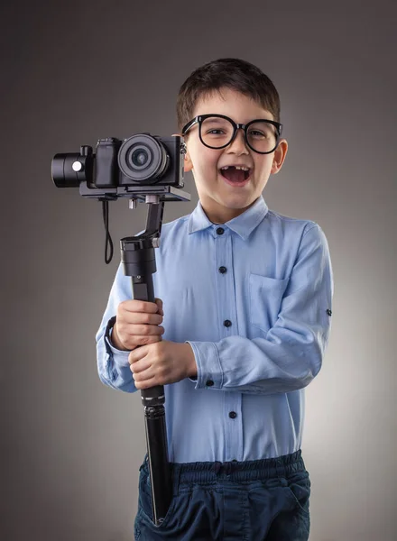 Симпатичный мальчик с электронным стабикамом на сером фоне — стоковое фото