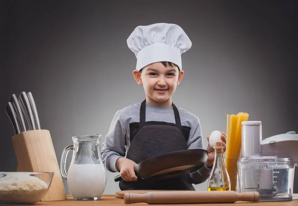 Aşçı çocuk Gri arka planda yemek pişiriyor. — Stok fotoğraf
