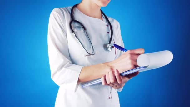 Femme médecin dans un manteau blanc et masque avec un stentoscope médecin écrit une prescription médicale — Video