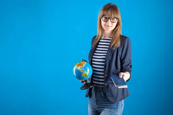 travel agent girl with passports tickets and globe on a blue background.
