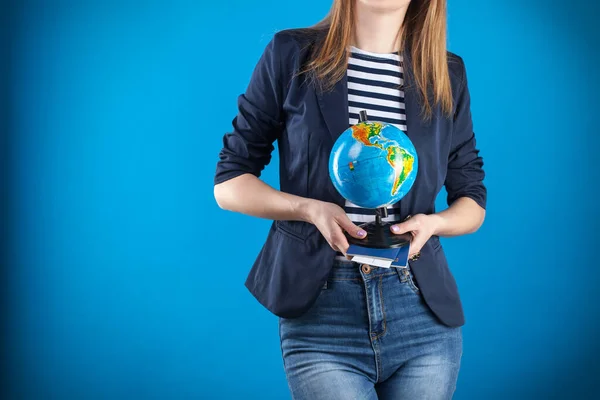 Travel agent girl with passports tickets and globe on a blue background. — Stock Photo, Image