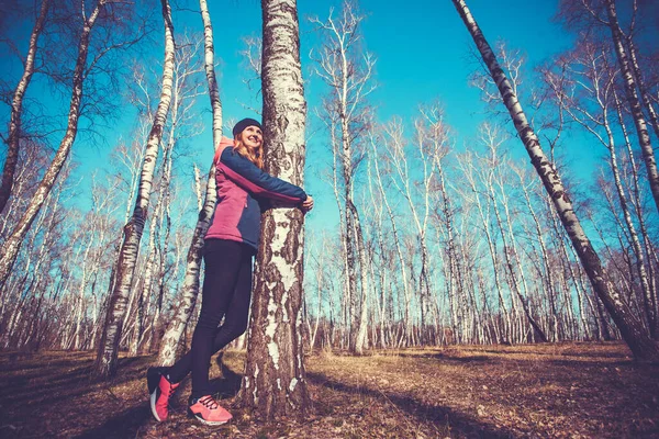 Young woman walks in a spring birch forest. — Stock Photo, Image