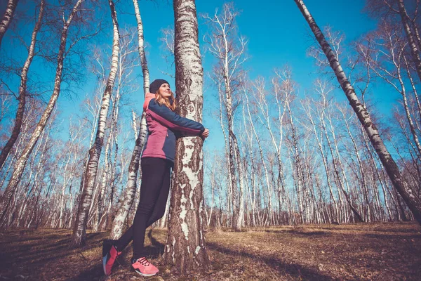 Giovane donna cammina in una foresta di betulla primaverile . — Foto Stock