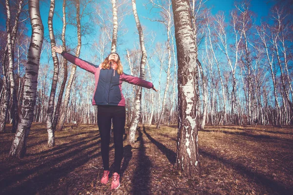 Jeune femme marche dans une forêt de bouleaux printaniers . — Photo