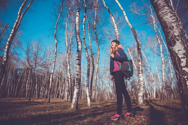 Mladá žena kráčí v jarním břízovém lese. — Stock fotografie