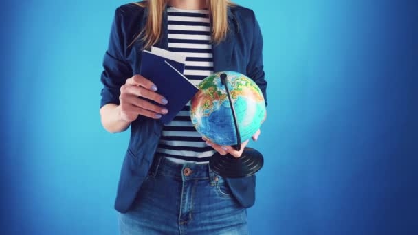 Travel agent girl with passports tickets and globe on a blue background. — Stock Video