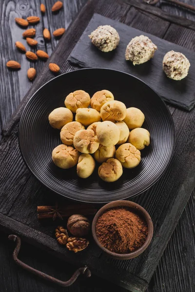 Deliziose palline di biscotti al cioccolato fatte in casa su uno sfondo di legno nero . — Foto Stock