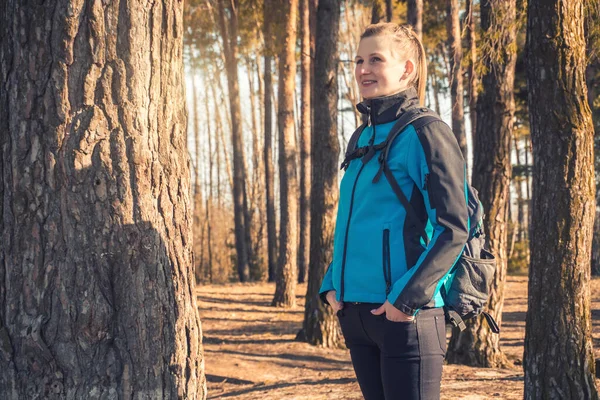 Ung kvinna går i en våren tallskog. — Stockfoto