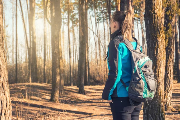 Jonge vrouw loopt in een lente dennenbos. — Stockfoto