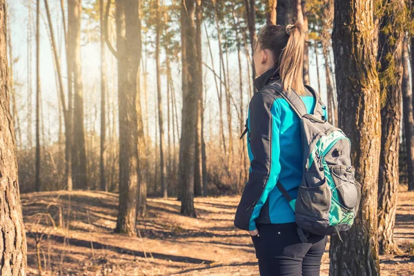 Jeune femme marche dans une pinède printanière . — Photo