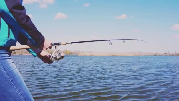 在湖上用钓竿钓鱼。女人的手与纺纱 — 图库视频影像